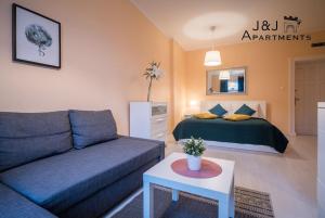 een woonkamer met een bank en een bed bij J&J Apartments - Szeroka 25, Apartament 5B in Toruń