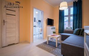 een woonkamer met een bank en een tafel bij J&J Apartments - Szeroka 25, Apartament 5B in Toruń