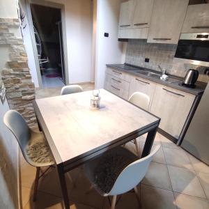 a kitchen with a wooden table and chairs at DGApartments Stella Alpina Livigno in Livigno