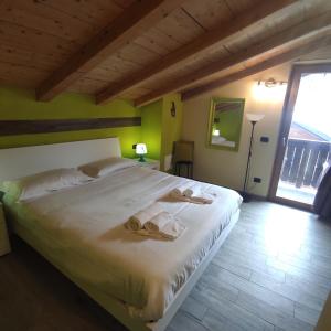 DGApartments Stella Alpina Livigno في ليفينو: غرفة نوم بسرير كبير عليها مناشف