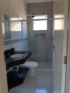 La salle de bains est pourvue d'un lavabo et de toilettes. dans l'établissement Chalés Airumã, à Caraguatatuba