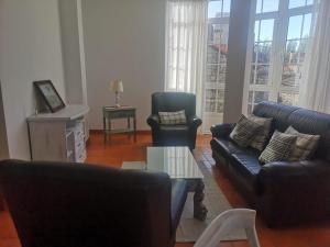 sala de estar con sofá, 2 sillas y mesa en Apartamento Bohemia, en Villanueva de Arosa