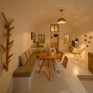 a living room with a couch and a table at Suite Home Santorini in Fira