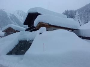 a pile of snow on the roof of a house at Le nid d'aigle in Arêches