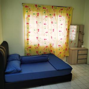 a bedroom with a bed and a curtain with red flowers at Taiping Desa Jana Home Stay in Kamunting