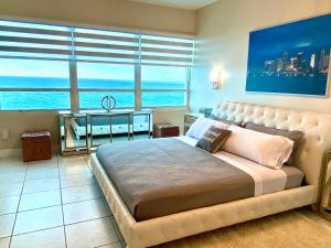 Schlafzimmer mit einem großen Bett und Meerblick in der Unterkunft Large luxurious direct ocean front Penthouse or Deluxe one bedroom ocean front condo-free parking in Miami Beach