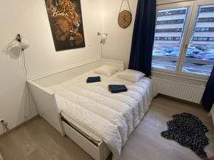 a white bed in a room with a window at Appartement Esplanade in Strasbourg