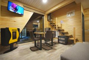 a room with a table and chairs and a tv at KubiA in Slănic-Moldova