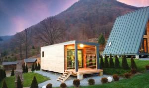 a tiny house in a field with a mountain in the background at KubiA in Slănic-Moldova