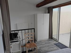 une chambre avec une chaise et une cuisine avec un balcon dans l'établissement Carpentras-Mont Ventoux, à Carpentras