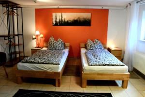 two beds in a room with an orange wall at Apartment Souterrain Bühl Vimbuch Familie Bork in Bühl