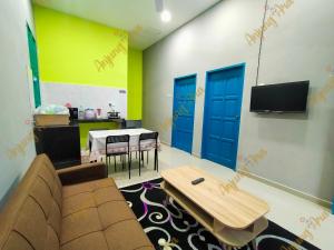 uma sala de estar com um sofá e uma mesa em anjung ara suites and roomstays em Kuala Terengganu