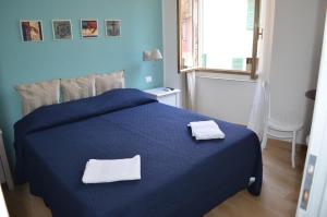 Una cama azul con dos toallas blancas. en Sottocoperta, en Riomaggiore