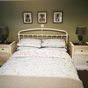 a bedroom with a white bed with two night stands at Rooms by the River at Glan Aber in Corwen