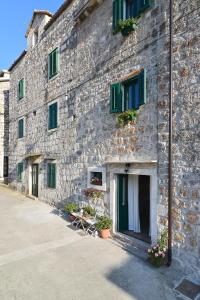 a brick building with a stone wall and windows at Apartments and Rooms Kampanel in Hvar