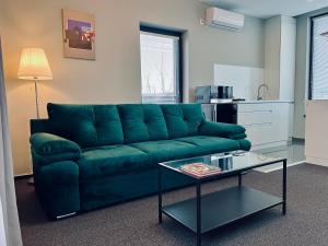 een woonkamer met een groene bank en een tafel bij 22 Residence in Braşov