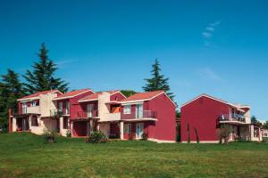 a row of houses sitting on a grass field at Apartments Katoro Plava Laguna in Umag