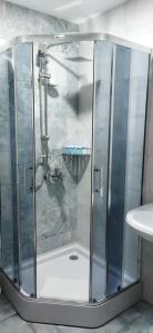 een douche met een glazen deur in de badkamer bij Vere Corner Hotel in Tbilisi City