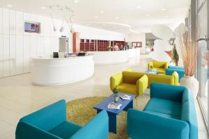 a lobby with blue and yellow chairs and a counter at Apartments Katoro Plava Laguna in Umag
