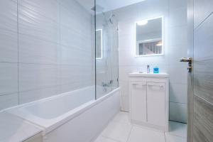 y baño blanco con ducha, bañera y lavamanos. en Cestrian House, en Chester 24 fotos más