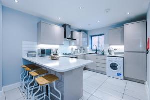 a large kitchen with white appliances and a large island at Cestrian House in Chester