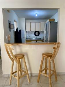 een keuken met twee houten krukken in een bar bij Apartamento Rodadero in Gaira