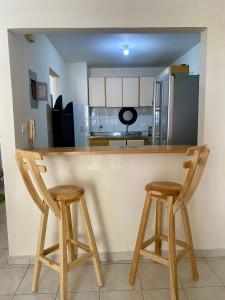 a kitchen with two wooden stools at a bar at Apartamento Rodadero in Gaira +2 photos