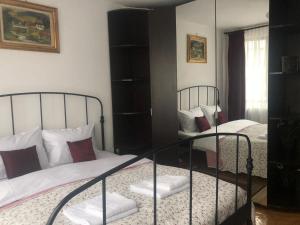 a bedroom with two beds and a mirror at Marie Apartment in Bucharest