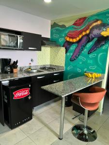 a kitchen with a painting of a dinosaur on the wall at Apartamento Tropical Playa Coronado in Playa Coronado