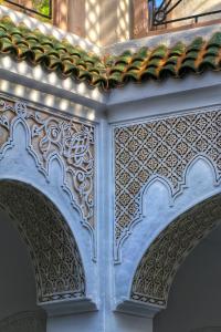 una pared blanca con diseños intrincados en ella en Riad Dollar Des Sables & Spa, en Marrakech