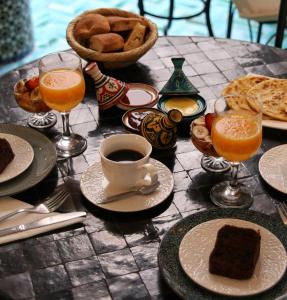 a table topped with plates of food and drinks at Riad Dollar Des Sables & Spa in Marrakesh