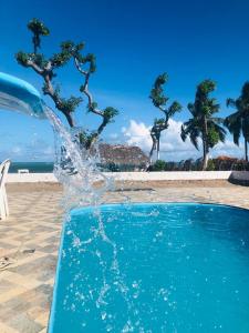 ein Spritzer Wasser in einem Pool neben einem Strand in der Unterkunft Villa D Mariscos in Paripueira