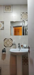 een badkamer met een witte wastafel en een spiegel bij Vere Corner Hotel in Tbilisi City