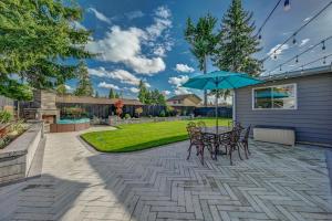 un patio con mesa, sillas y sombrilla en Renton Oasis- Relaxing 3BR Home with Great Outdoor! home, en Renton