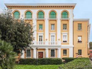 a large yellow building with green windows at Maison boutique Matteotti in Matera