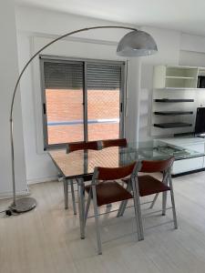 una mesa de cristal y sillas en una cocina con lámpara en Cañitas 3amb cochera fija techada solo CON RESERVA en Buenos Aires