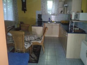 a kitchen with a table and chairs and a table and a kitchen at Elefánt Apartment in Keszthely