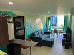 a living room with a couch and a painting on the wall at Apartamento Tropical Playa Coronado in Playa Coronado