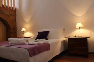 a bedroom with a bed with white sheets and two lamps at Casa da Estalagem - Turismo Rural in Ervidel