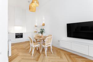 une cuisine blanche avec une table et des chaises ainsi qu'une télévision dans l'établissement 44 Renshaw Apart Hotel, à Liverpool