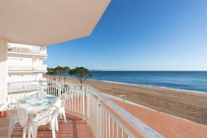 a balcony with a table and chairs on the beach at Hauzify I Apartament Cannes in Platja d'Aro