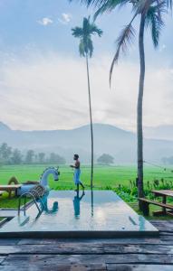 eine Person, die auf einem Pool mit Palmen steht in der Unterkunft Coconut Escapes in Kurunegala