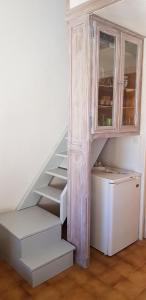 - un escalier avec une armoire et un réfrigérateur dans la chambre dans l'établissement Villa Naturiste NATURE Héliovillage 104, au Cap d'Agde