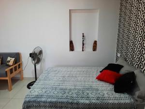 a bedroom with a bed and a fan at Guest House Maio in Vila do Maio