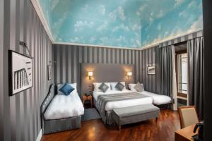 1 dormitorio con 2 camas y techo azul en Monti Palace Hotel, en Roma