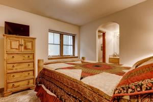 a bedroom with a bed and a dresser with a television at Breckenridge Luxury Condo, Easy Access to Ski Lifts! in Breckenridge