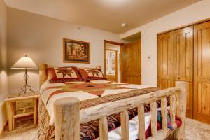 a bedroom with a wooden bed in a room at Los Pinos - Luxury Breckenridge SkiCondo in Breckenridge +21 photos