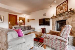 sala de estar con 2 sofás y chimenea en Los Pinos - Luxury Breckenridge SkiCondo, en Breckenridge