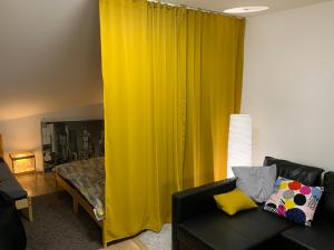 ロジュノフ・ポト・ラドホシュチェムにあるApartmány Tyloviceのリビングルーム(黄色のカーテン、ソファ付)