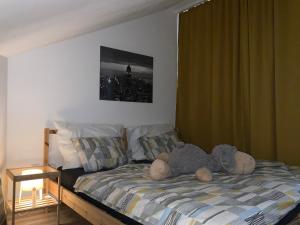 een knuffeldier op een bed in een slaapkamer bij Apartmány Tylovice in Rožnov pod Radhoštěm